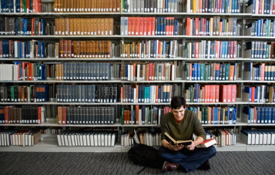 Young Man Reading in Library --- Image by © Greg Hinsdale/Corbis